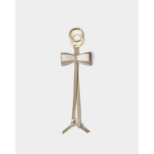 Our Bow Charm Keyring in Taupe features a sweet bow-shaped design, stamped with the sweet sentiment ‘Loved’. Finished with gold-tone signature charm detailing.
