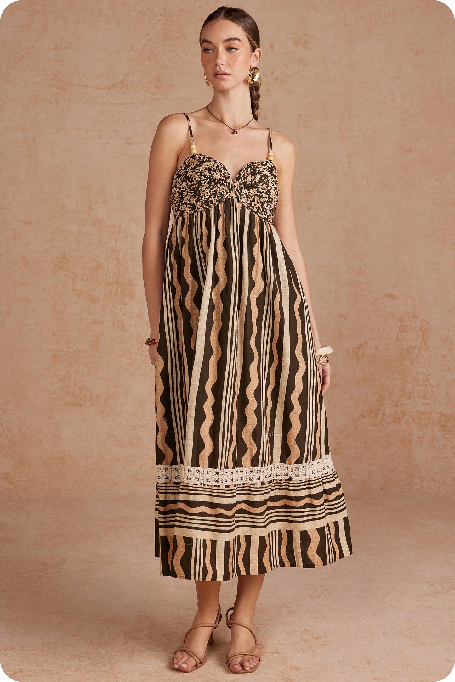 Effortlessly elegant and perfect for sunny days, this printed linen midi dress features delicate braided details and spaghetti straps for a timeless, feminine look.

