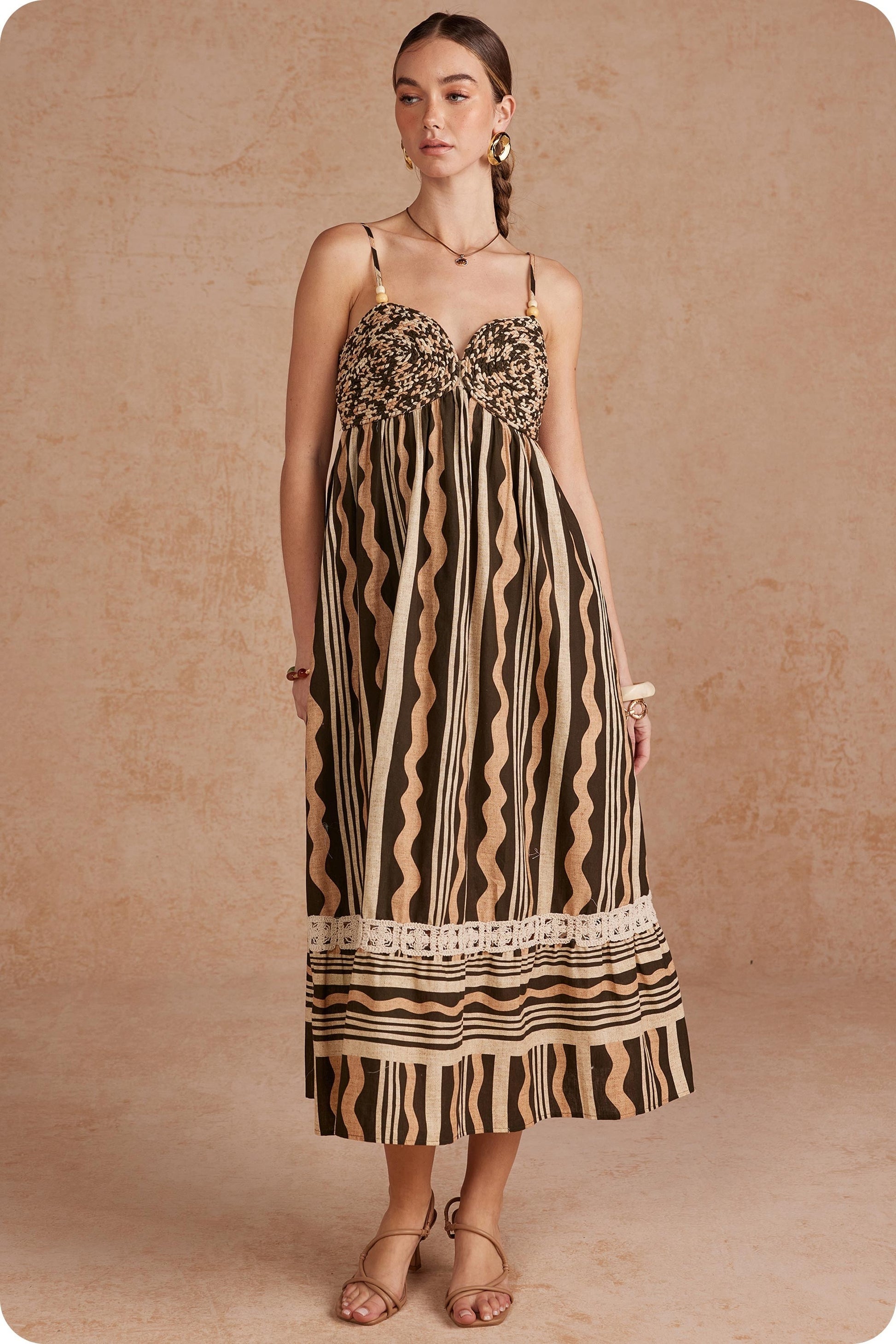 Effortlessly elegant and perfect for sunny days, this printed linen midi dress features delicate braided details and spaghetti straps for a timeless, feminine look.


