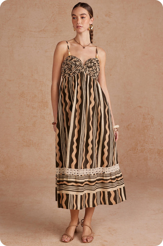 Effortlessly elegant and perfect for sunny days, this printed linen midi dress features delicate braided details and spaghetti straps for a timeless, feminine look.


