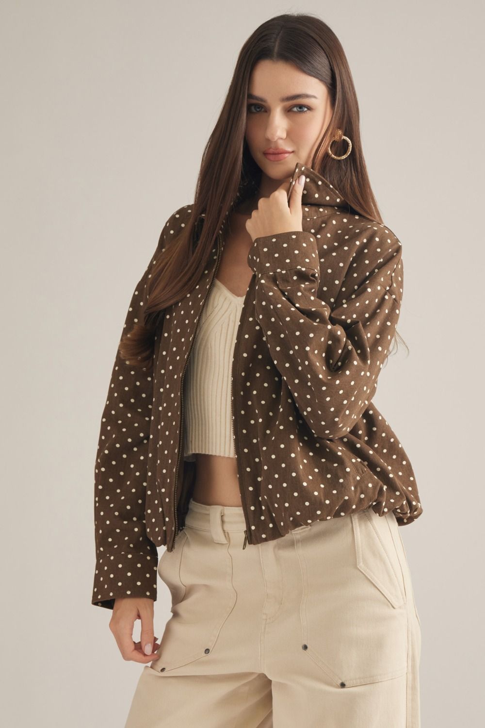 A lightweight polka dot jacket featuring a collared neckline, zip-front closure, and elastic hem for effortless everyday layering.
