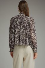 A romantic printed blouse featuring voluminous puff sleeves, a feminine ruffle neckline, and delicate gathered details for an effortlessly polished look.