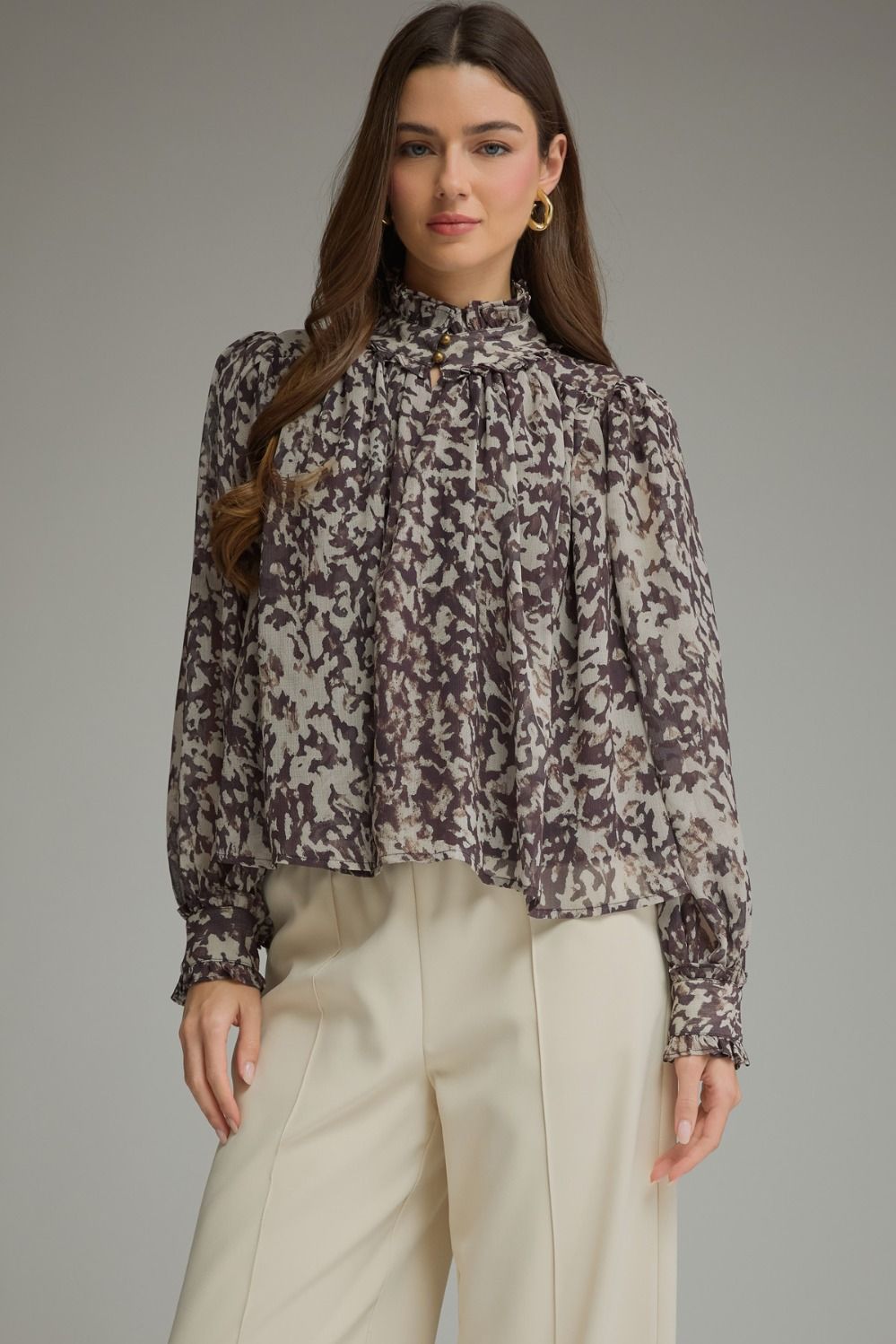 A romantic printed blouse featuring voluminous puff sleeves, a feminine ruffle neckline, and delicate gathered details for an effortlessly polished look.