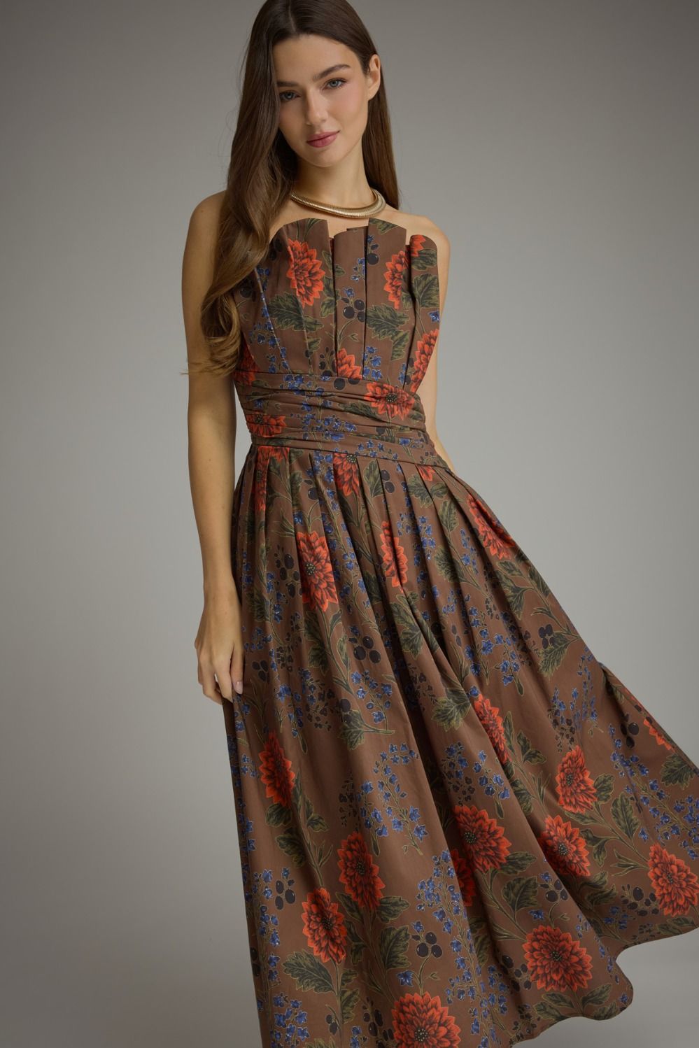 A feminine floral midi dress featuring a unique neckline created by the beautifully pleated bodice, comfortable smocked back, and convenient side pockets.