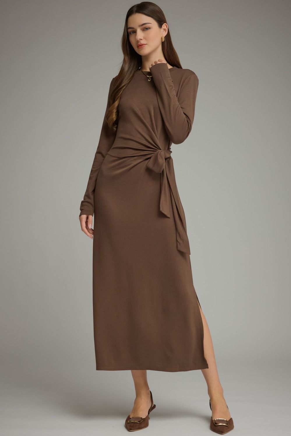 A sleek and effortlessly flattering long sleeve midi dress featuring a soft knit feel, adjustable side-tie waist, and chic side slit.