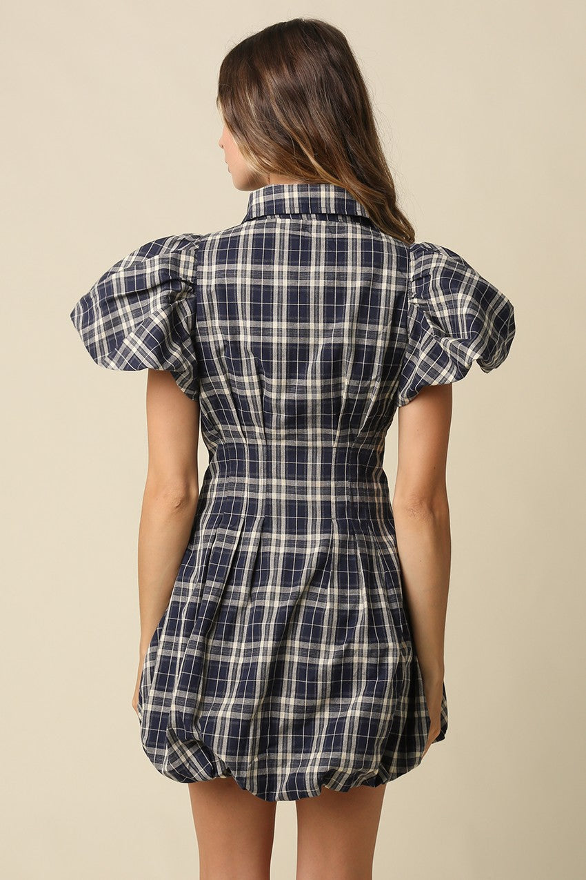 A fashion-forward plaid mini dress featuring a collared zip-front neckline, puff sleeves, and a voluminous bubble hem for standout seasonal style.