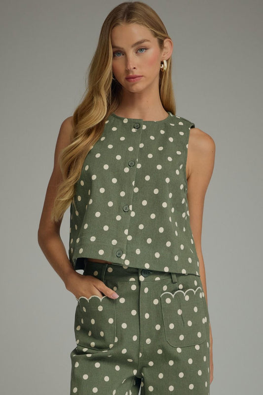 A timeless polka dot sleeveless top with a classic round neckline and button-front detail for effortless everyday style.
