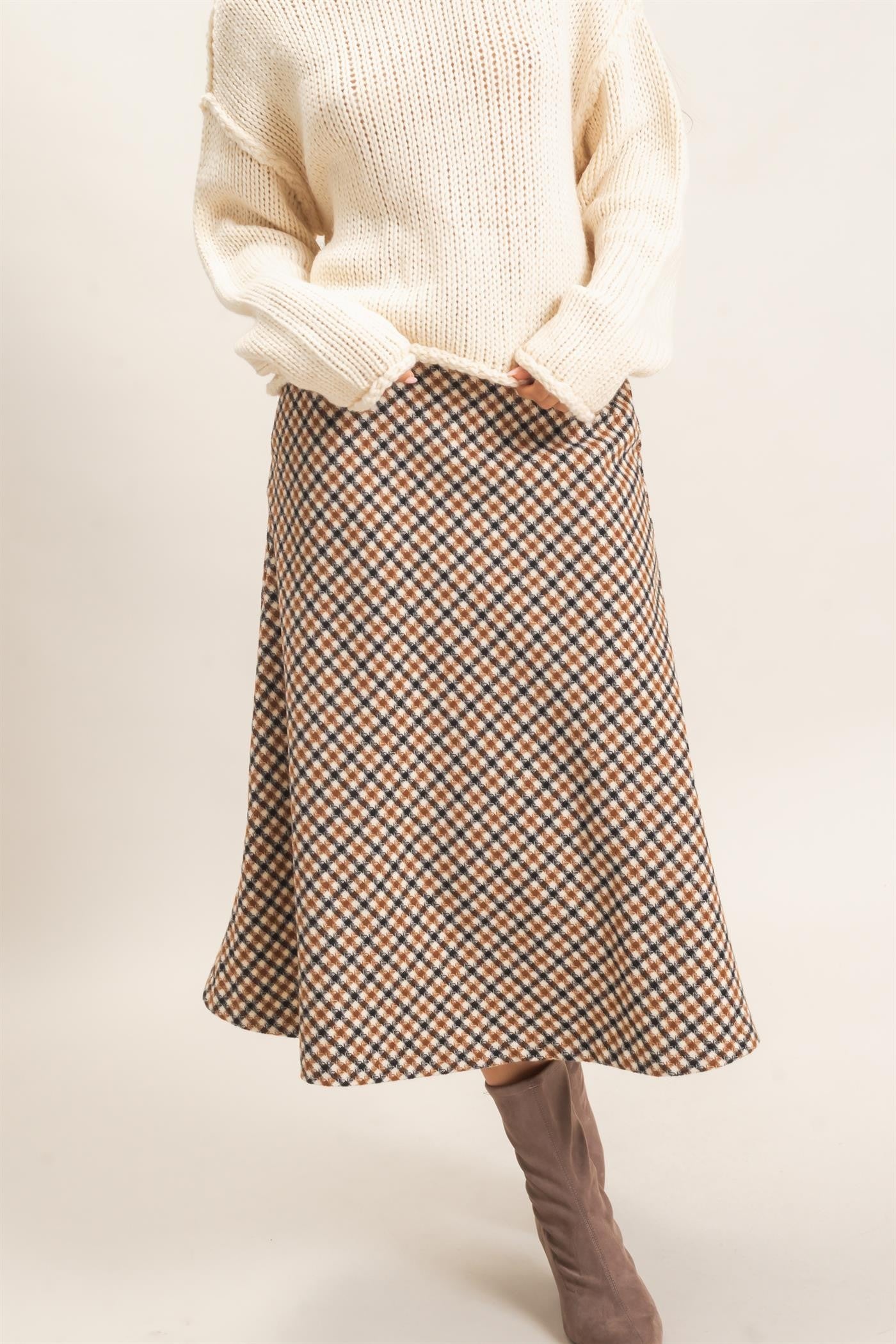 A sophisticated checkered A-line midi skirt featuring a sleek faux leather waistband and flattering flare for effortlessly polished style.
