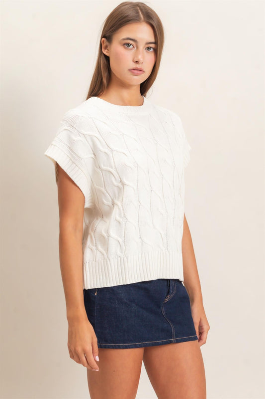A timeless cable knit sweater featuring a classic crew neckline and cap sleeves for an effortlessly polished look you'll wear year-round.