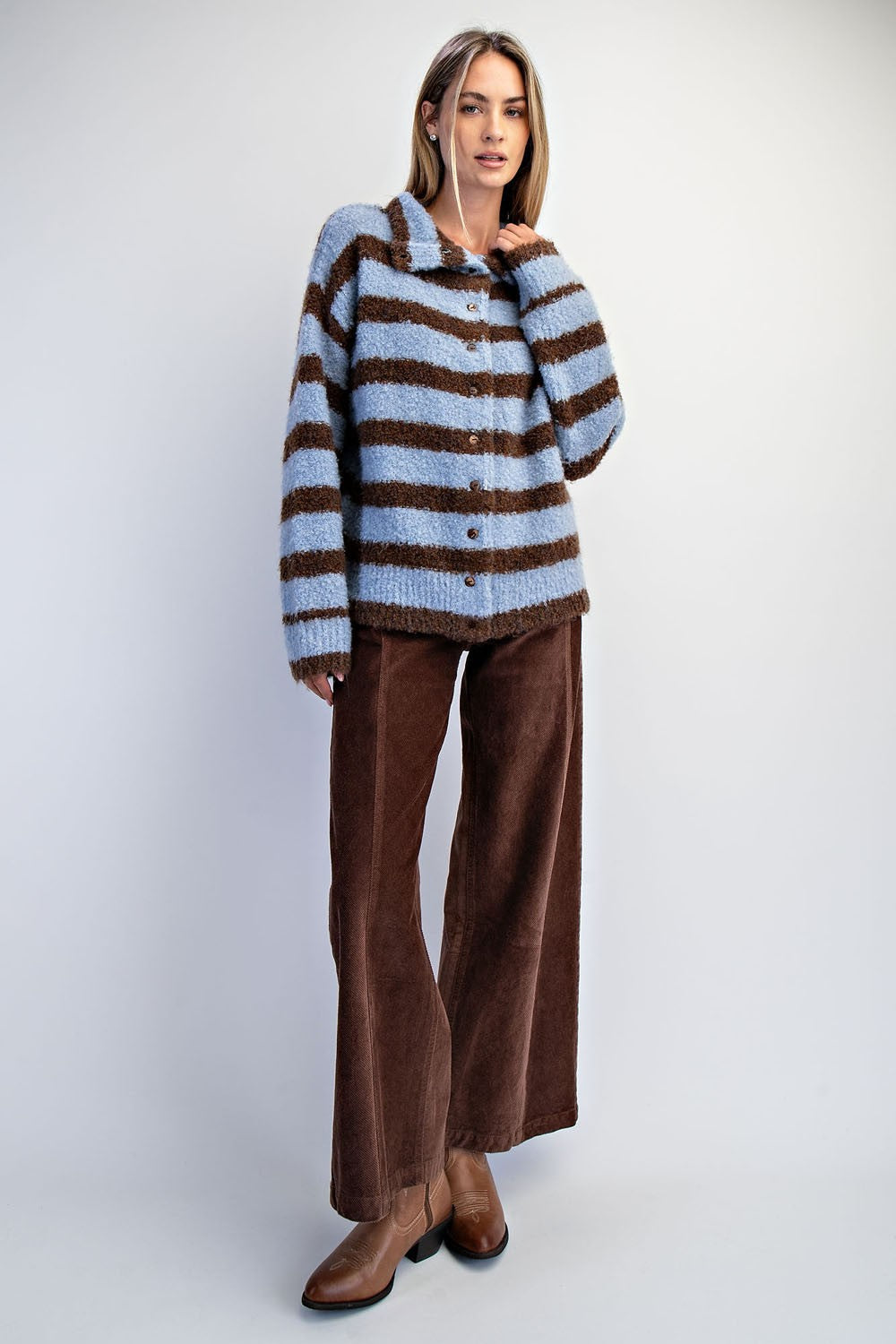 A cozy textured knit cardigan featuring a relaxed slouchy fit, dropped shoulders, and playful mismatched buttons for a unique finishing touch.