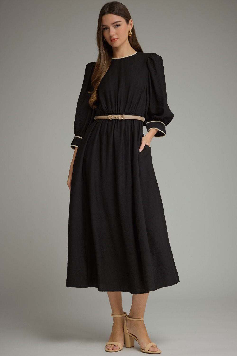 A polished ¾-sleeve midi dress featuring feminine puff sleeves, contrast piping, a defined elastic waist, and a removable buckle belt.