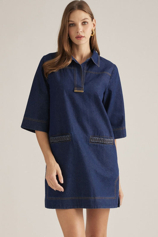 A playful printed mini dress featuring a polished collar, V-neckline, contrast topstitching, and convenient side pockets for effortless everyday style.

