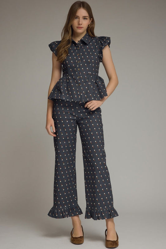 A playful polka dot denim top featuring cap sleeves, a collared neckline, and a flattering peplum hem for effortlessly feminine style.