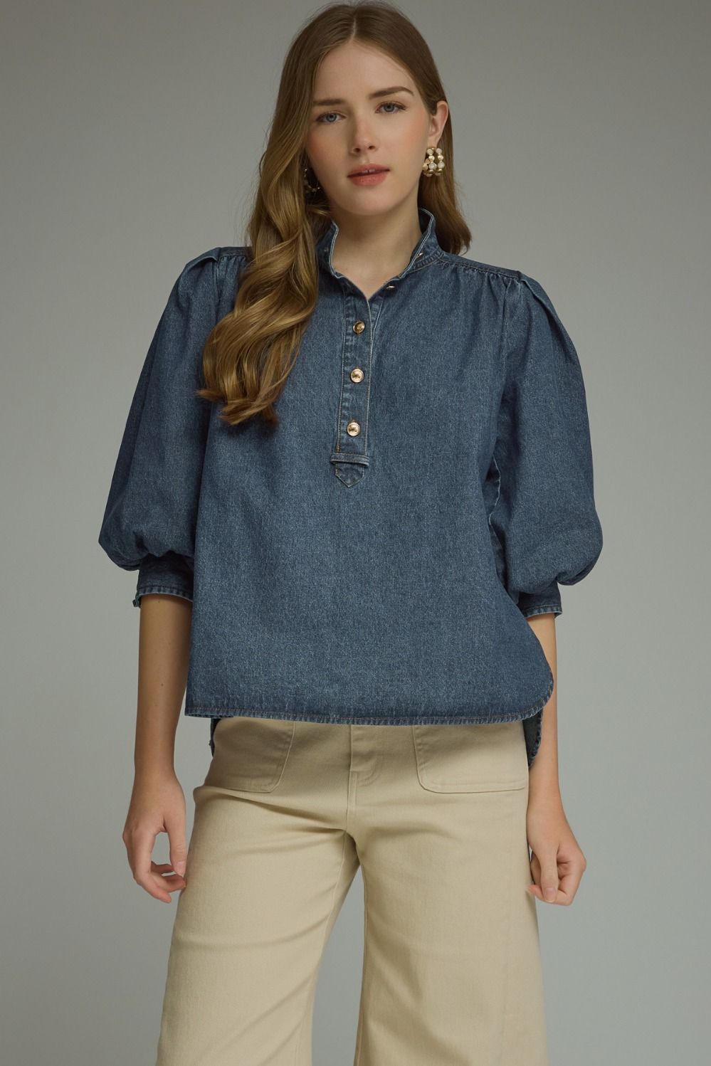 A feminine lightweight denim top featuring romantic ¾ puff sleeves, a classic button-front closure, and adjustable self-tie cuffs for a polished everyday look.