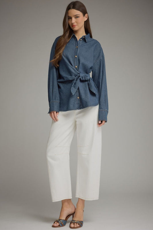 A chic lightweight denim top featuring a classic button front, flattering wraparound self-tie waist, and polished button cuffs.

