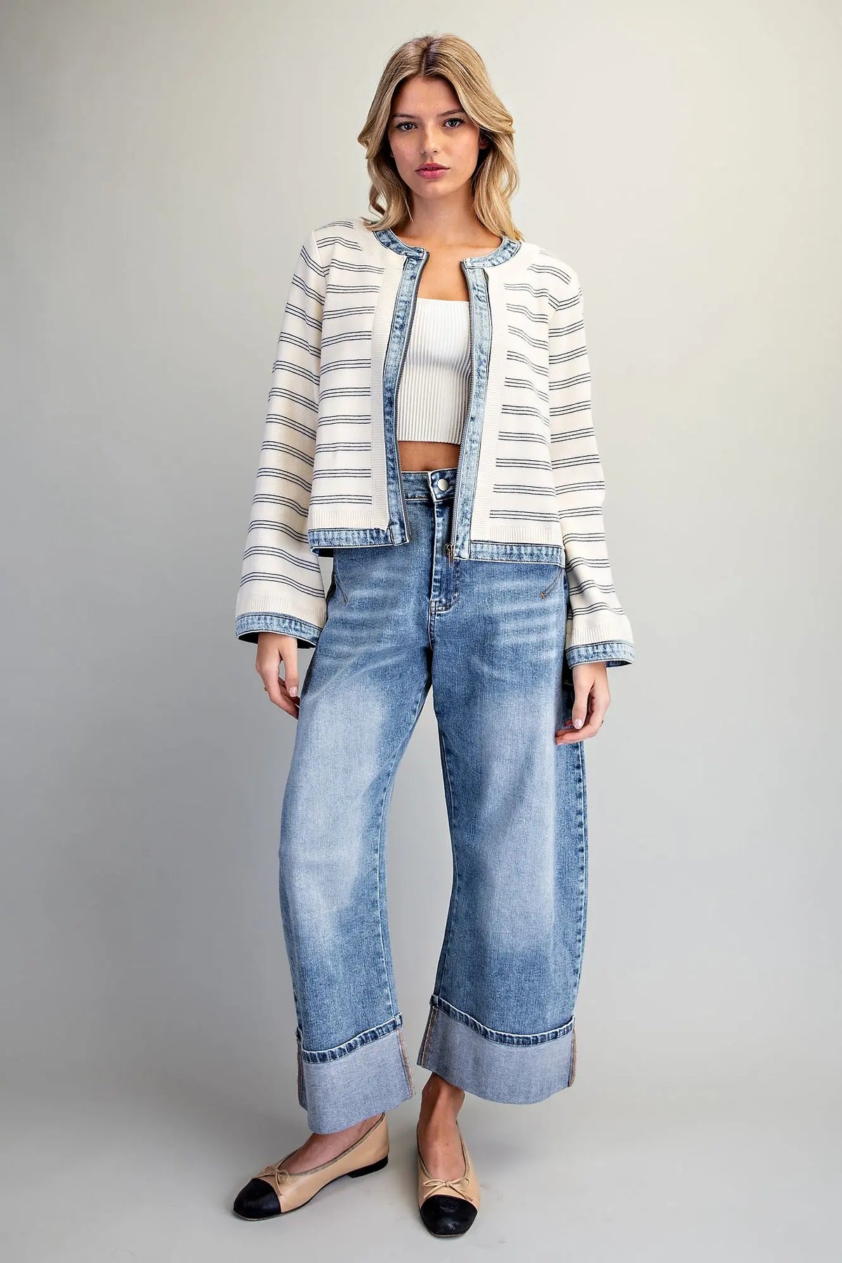 A casually chic striped knit jacket featuring contrasting washed denim trim, a zip-front closure, and a slightly cropped silhouette.
