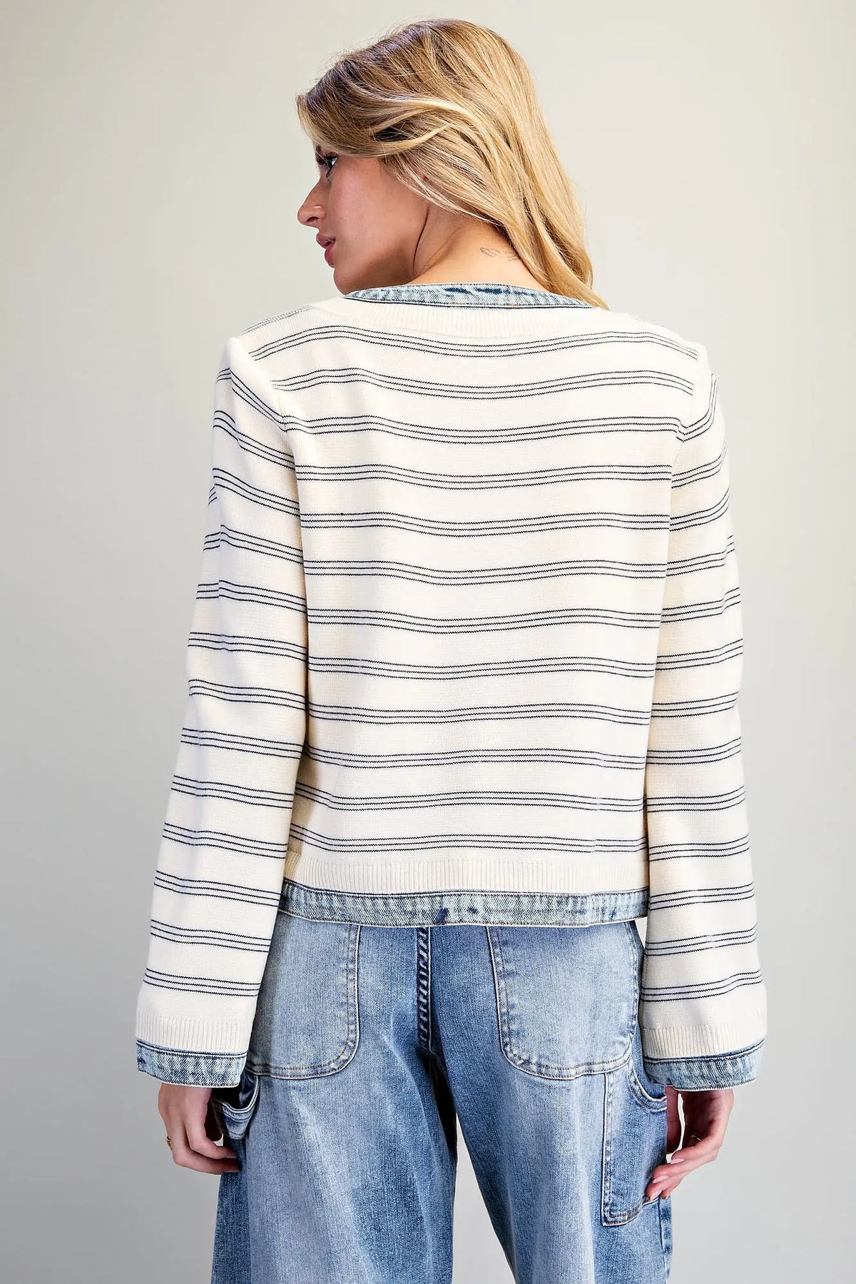 A casually chic striped knit jacket featuring contrasting washed denim trim, a zip-front closure, and a slightly cropped silhouette.
