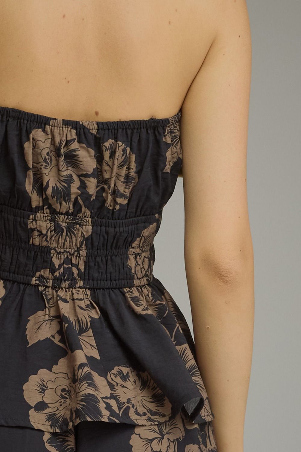 A feminine floral peplum top featuring a straight neckline, adjustable tie straps, smocked waist, and lightweight lined design for effortless summer style.