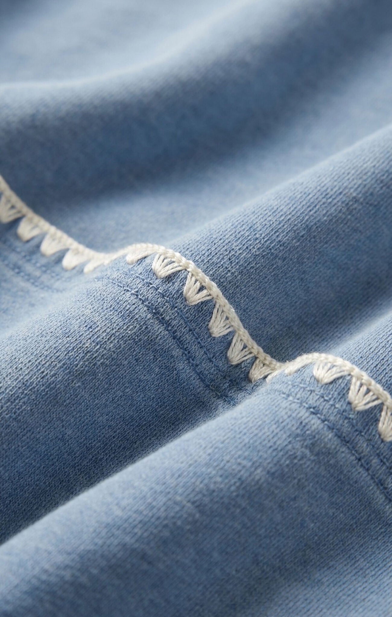 detail cropped denim-inspired jacket crafted from soft French terry knit for comfortable layering with a modern casual feel.