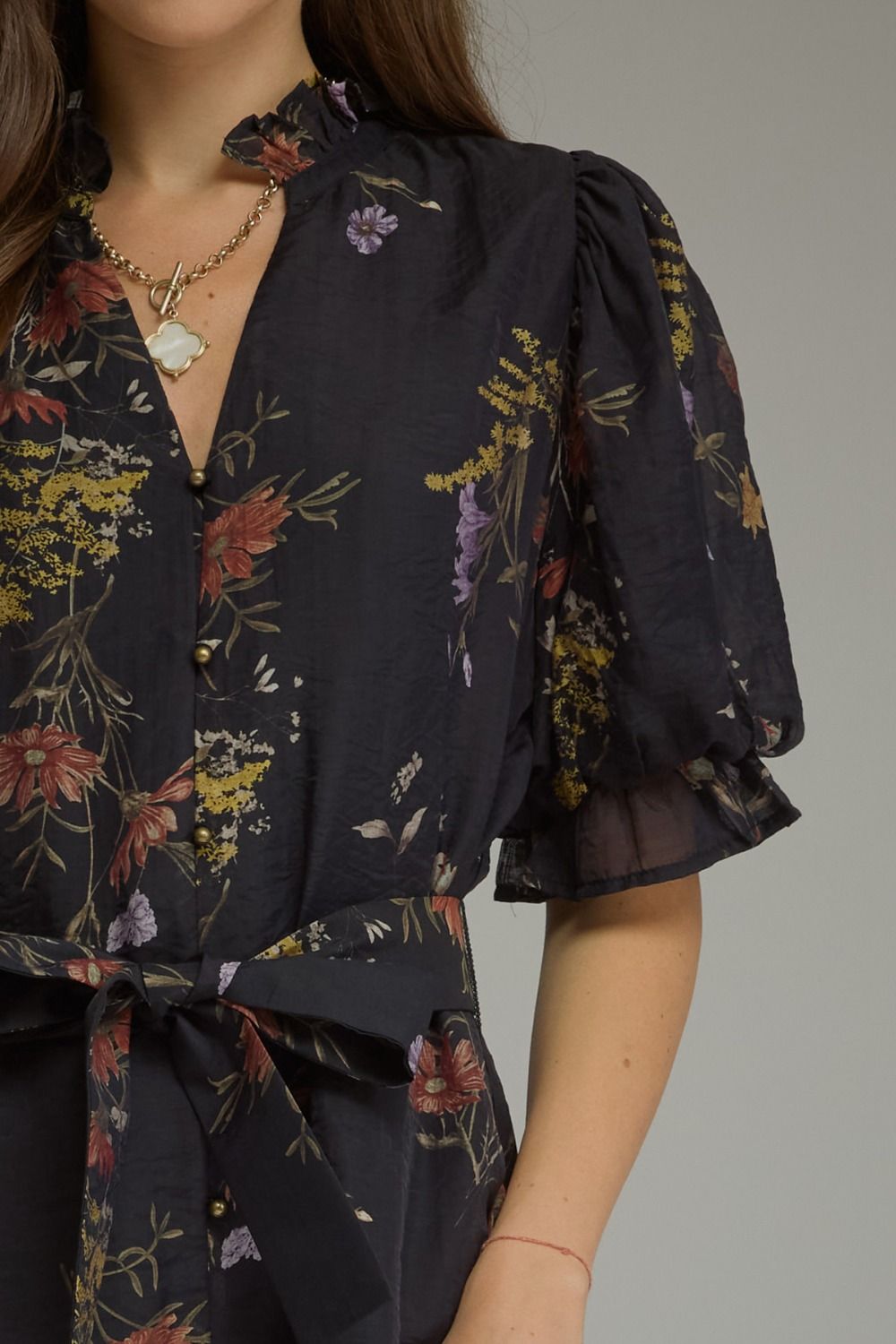 A romantic floral mini dress featuring puff sleeves, a self-tie waist belt, and a ruffled V-neckline for effortlessly feminine style.
