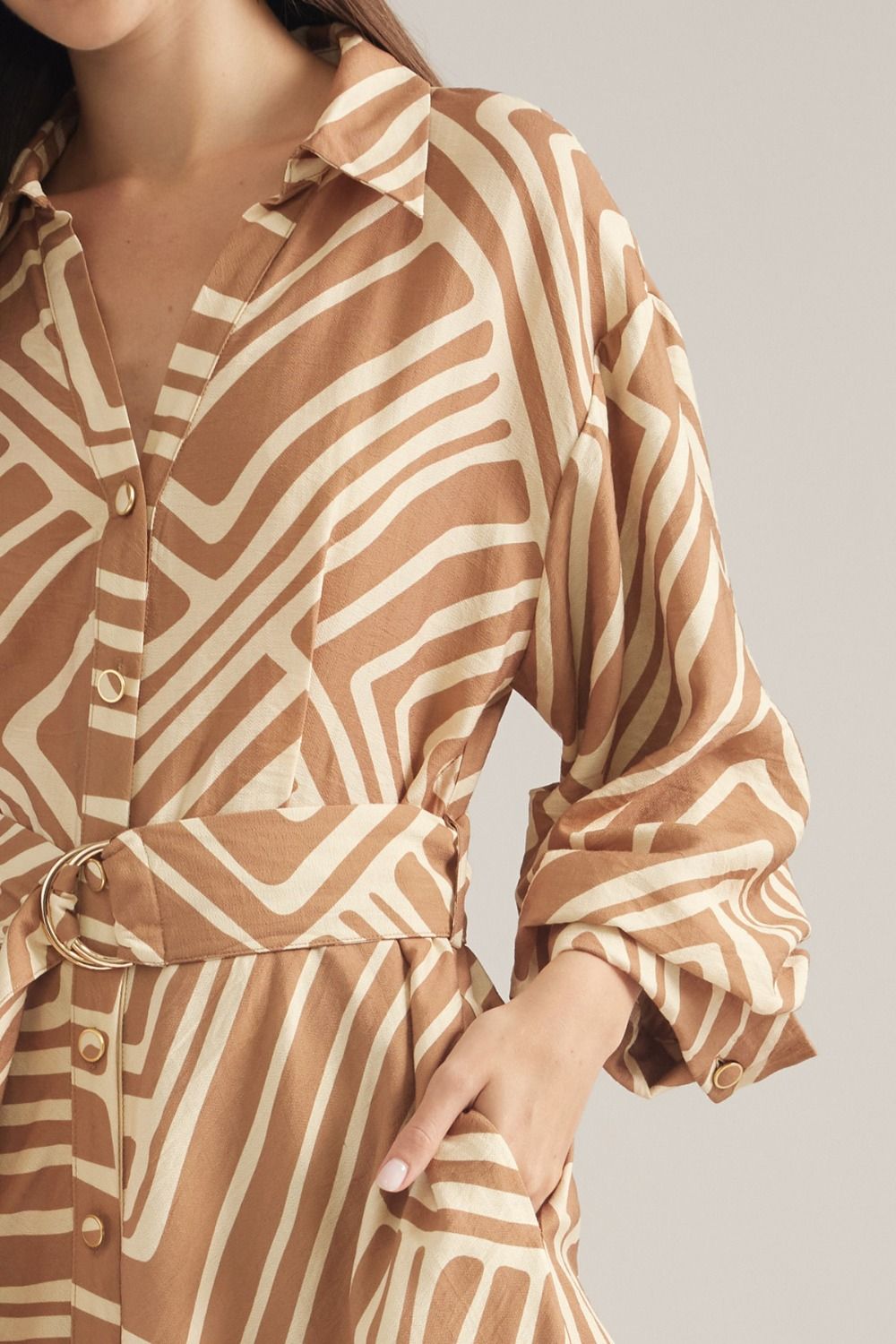 A sophisticated geometric print midi dress featuring balloon sleeves, a removable belt, and a flattering button-front silhouette.
