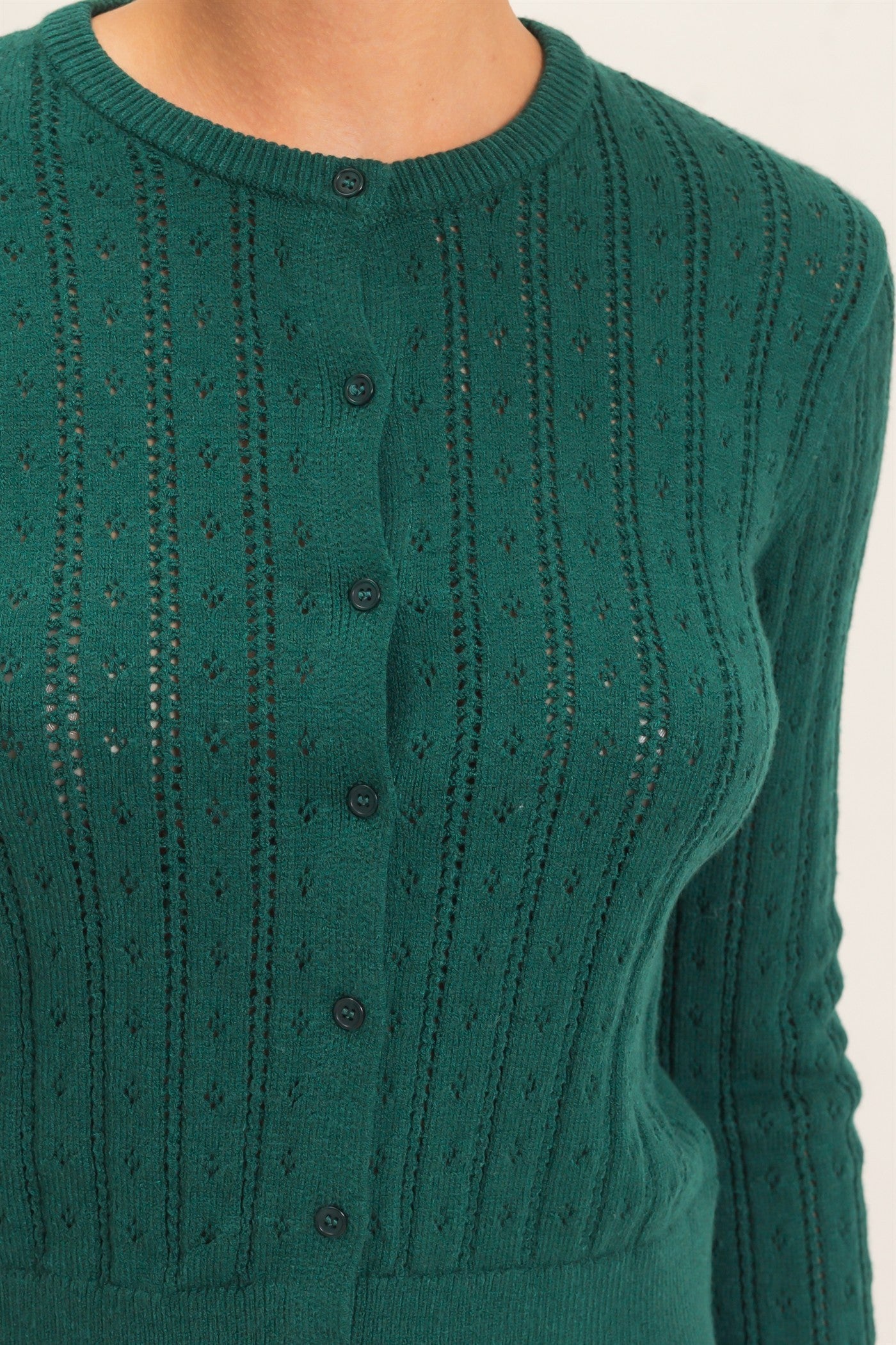 A timeless pointelle knit cardigan featuring a classic button-front design, ribbed crew neckline, and a tailored silhouette for effortless everyday elegance.