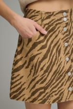 A bold zebra print mini skirt featuring a button-front design, front pocket details, and a flattering everyday silhouette.
