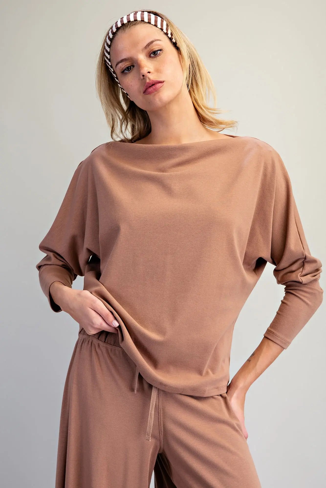 An effortlessly chic knit top featuring an elegant boat neckline, relaxed dolman sleeves, and elongated cuffs for timeless everyday style