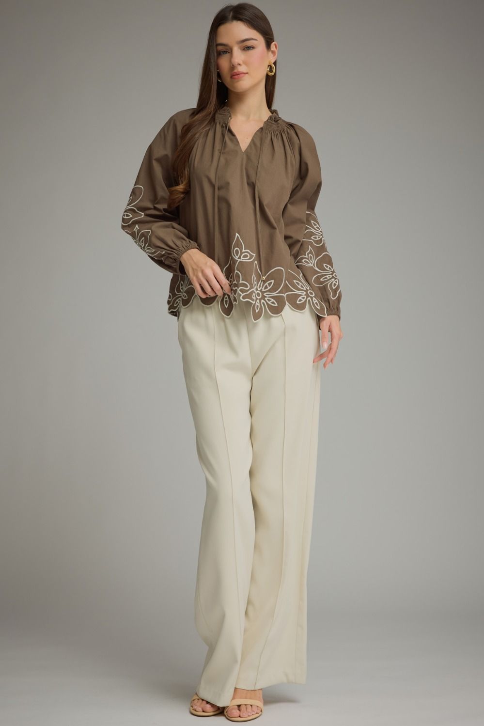 A charming lightweight woven top featuring a romantic ruffle neckline, self-tie front, and delicate embroidery for effortlessly feminine style.

