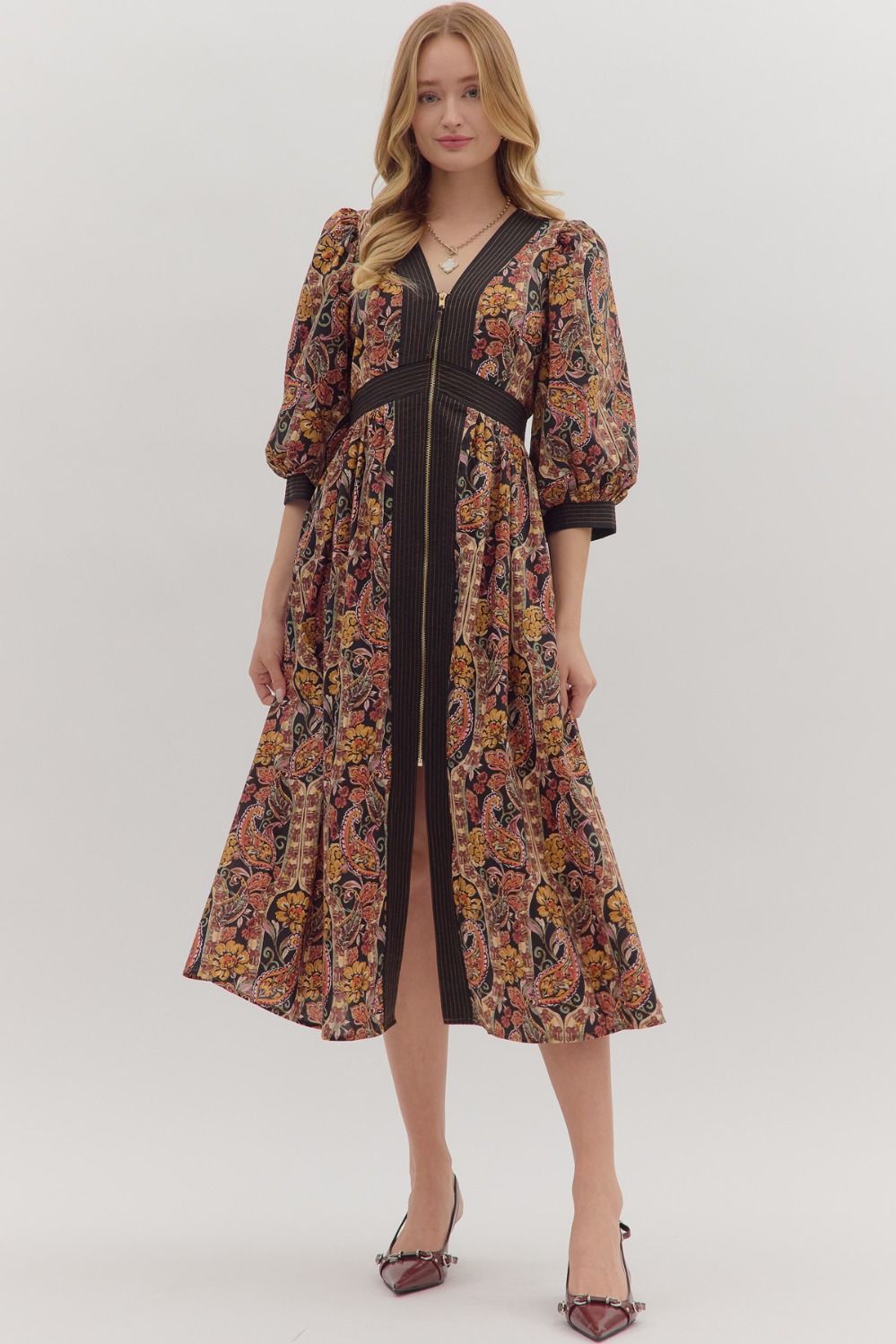 Charming and versatile, the Verena midi dress pairs a bold paisley print with striped trim, puff sleeves, and practical pockets.