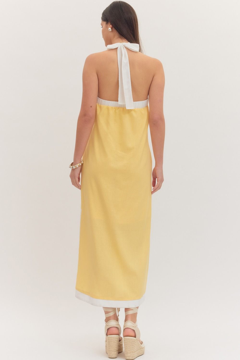 sleeveless midi dress with a cross halter neckline, self-tie back, side pockets, and side slits