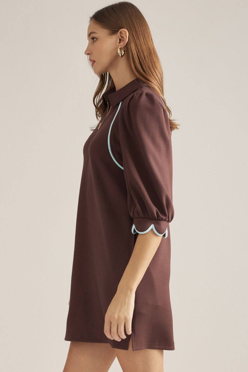 Solid knit mini dress with three-quarter puff sleeves, contrast piping, front zipper, scalloped cuffs, and side pockets