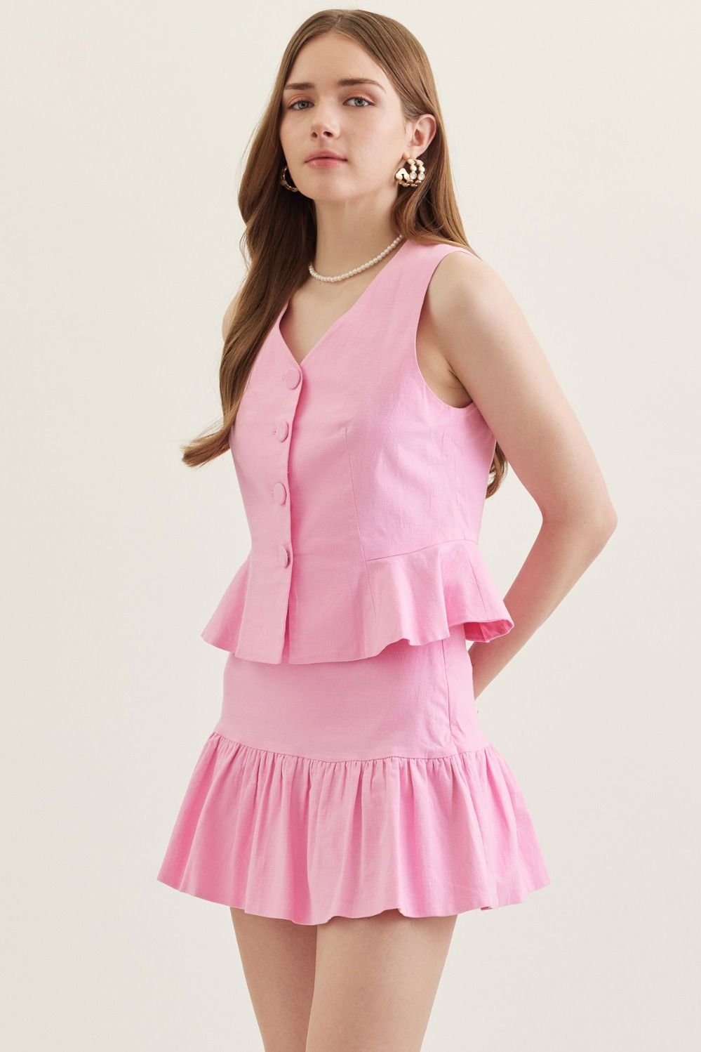 sleeveless vest with peplum hem, V-neckline, and front button closure