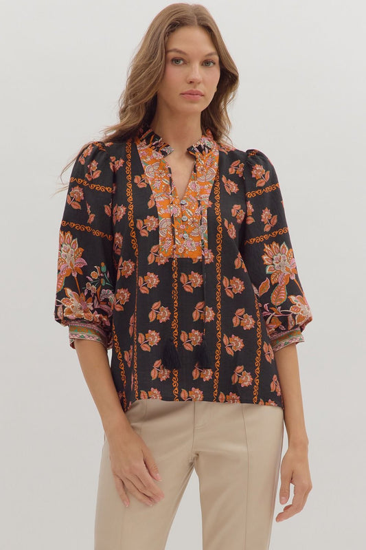Romantic and lightweight, the Isolde top features a ruffled band collar, tassel tie neckline, and effortless drape.