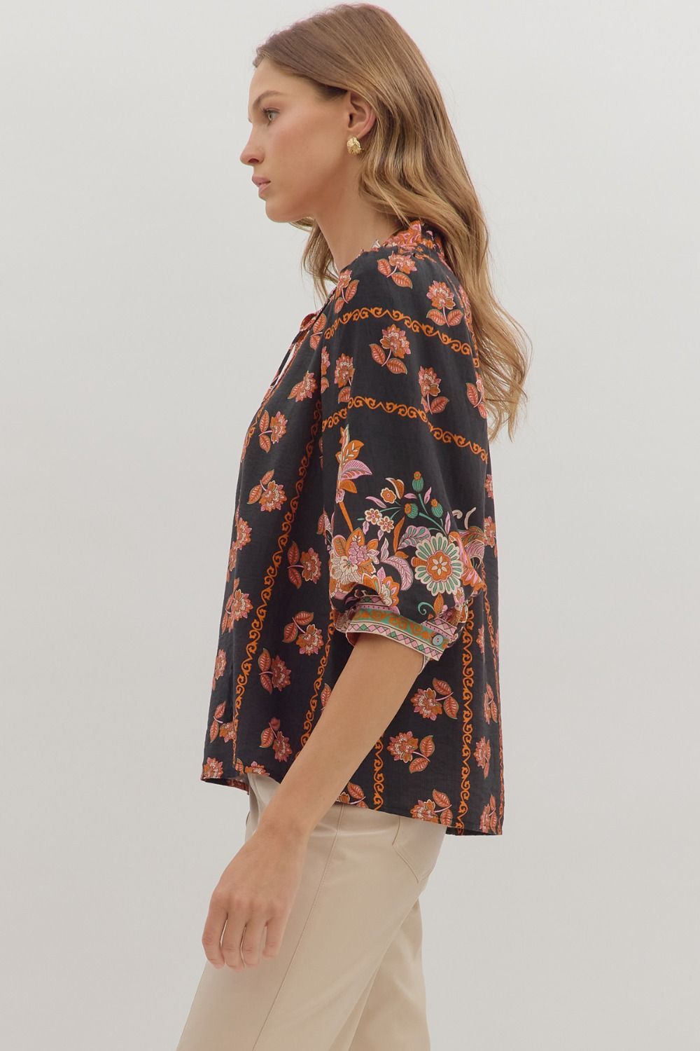 Romantic and lightweight, the Isolde top features a ruffled band collar, tassel tie neckline, and effortless drape.