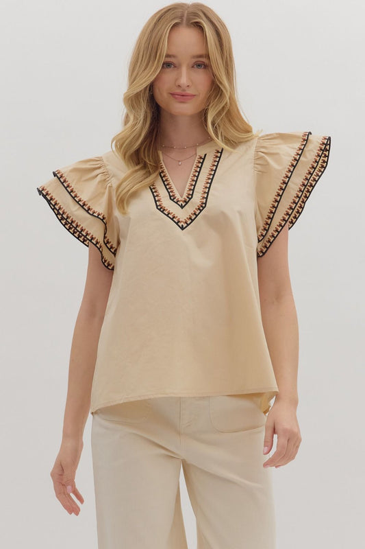 Feminine and breezy, the Odette top features layered flutter sleeves, a V-neck, and contrast embroidered trim for a polished finish.