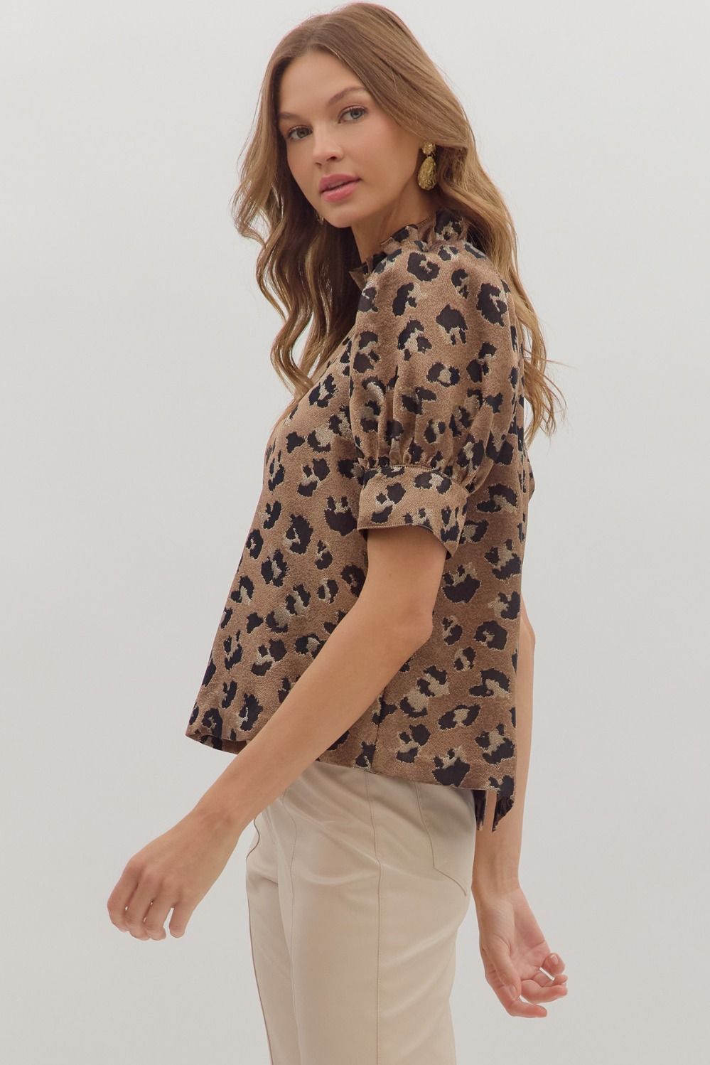 Fierce meets feminine in the Selene top, featuring a bold animal print, puff sleeves, and a ruffled mock neckline.
