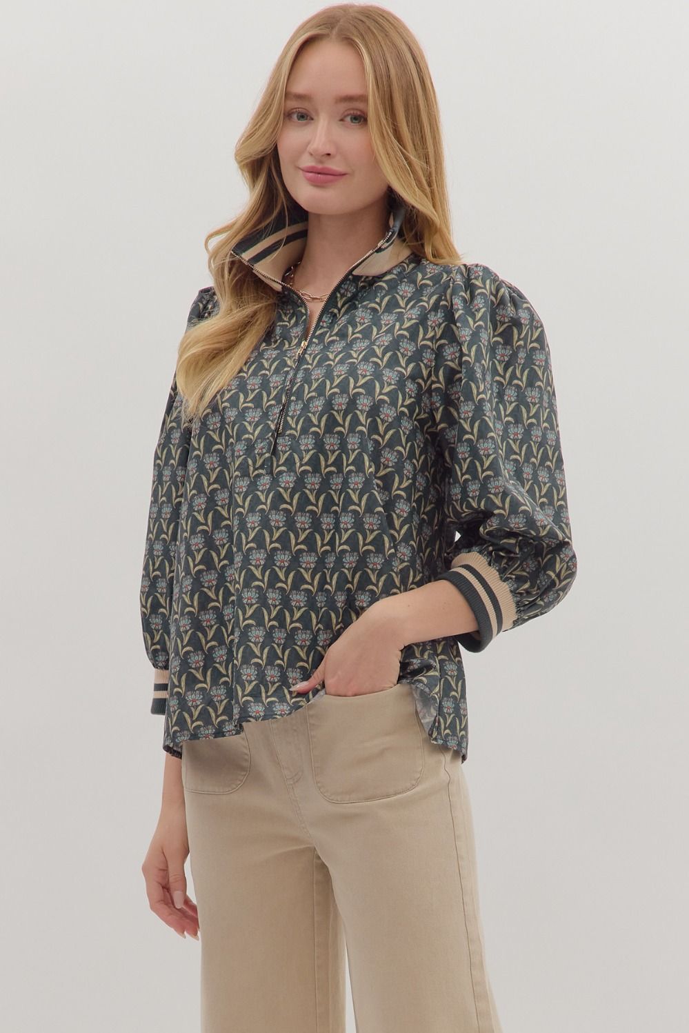 Sporty meets feminine in the Astrid top, featuring floral print puff sleeves with striped ribbed trim and a modern half-zip neckline.
