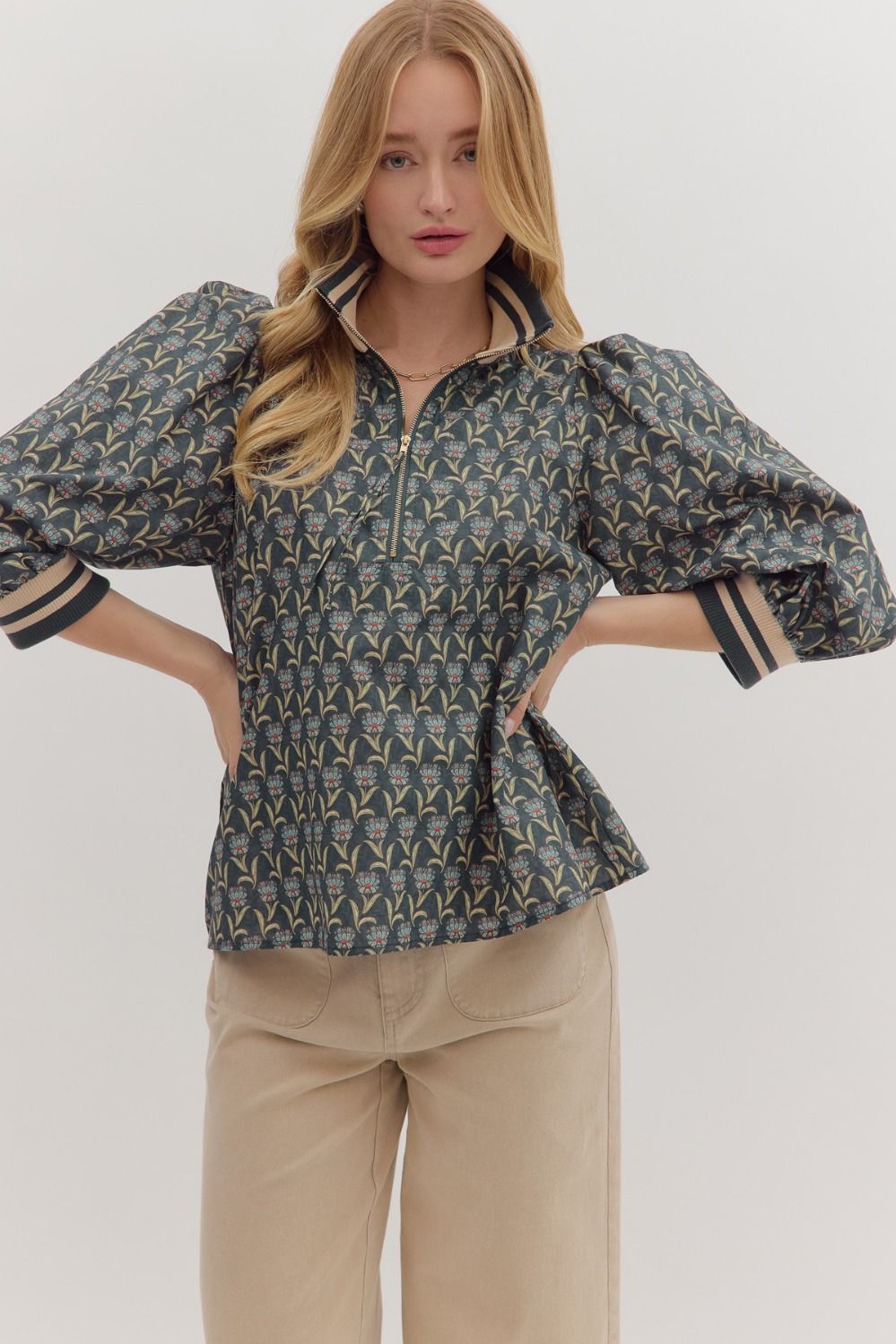 Sporty meets feminine in the Astrid top, featuring floral print puff sleeves with striped ribbed trim and a modern half-zip neckline.