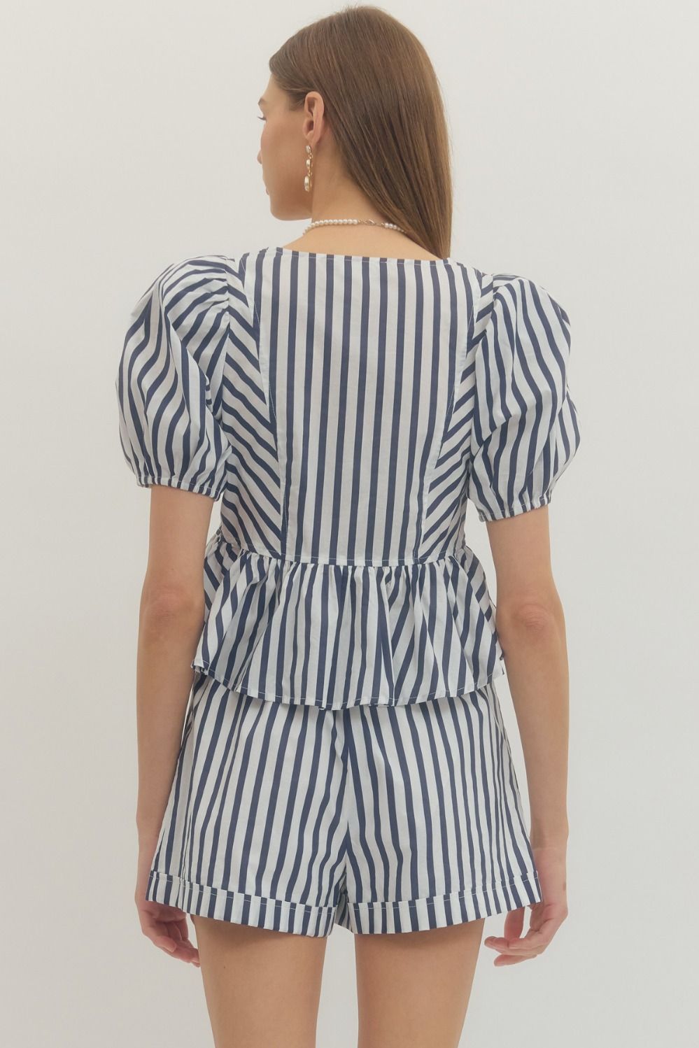 Stripe print puff sleeve peplum top with front self-tie bow detail and fabric-covered buttons.