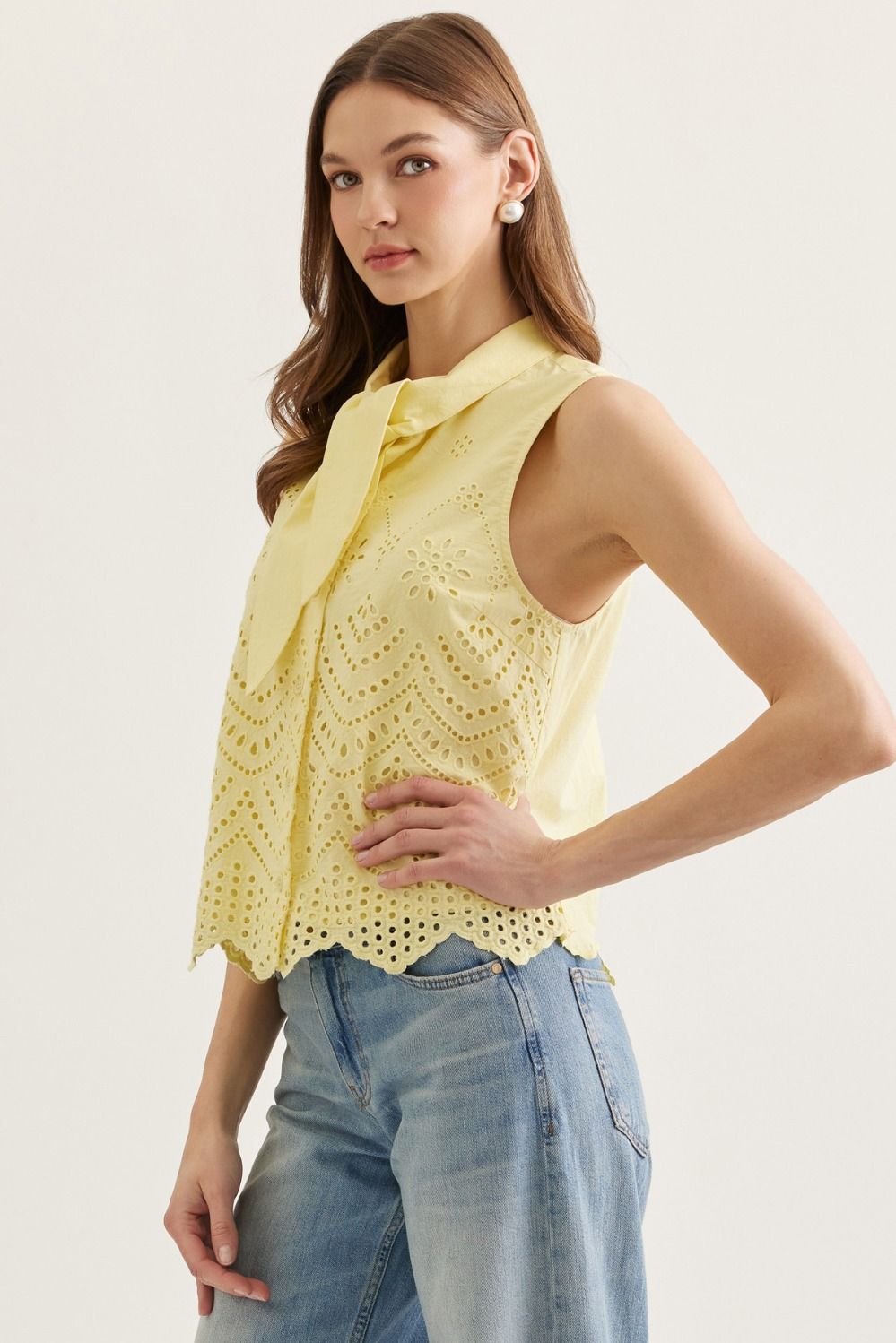 cotton sleeveless top with eyelet embroidery, tie-neck detail, and scalloped hem