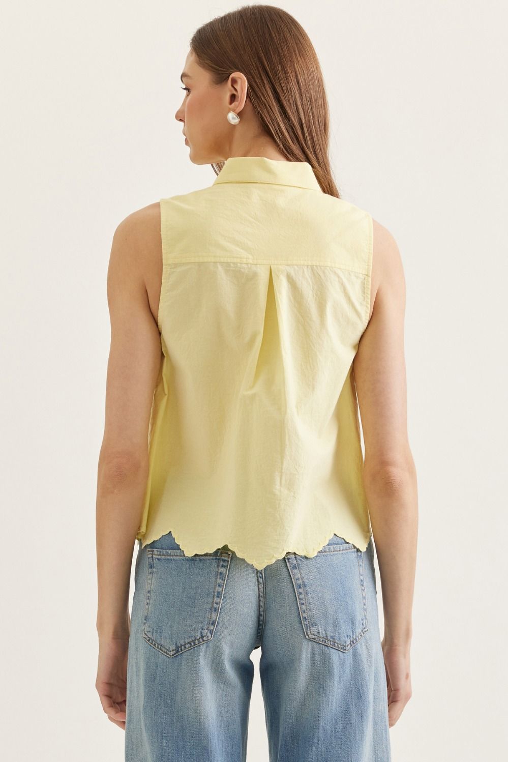 cotton sleeveless top with eyelet embroidery, tie-neck detail, and scalloped hem