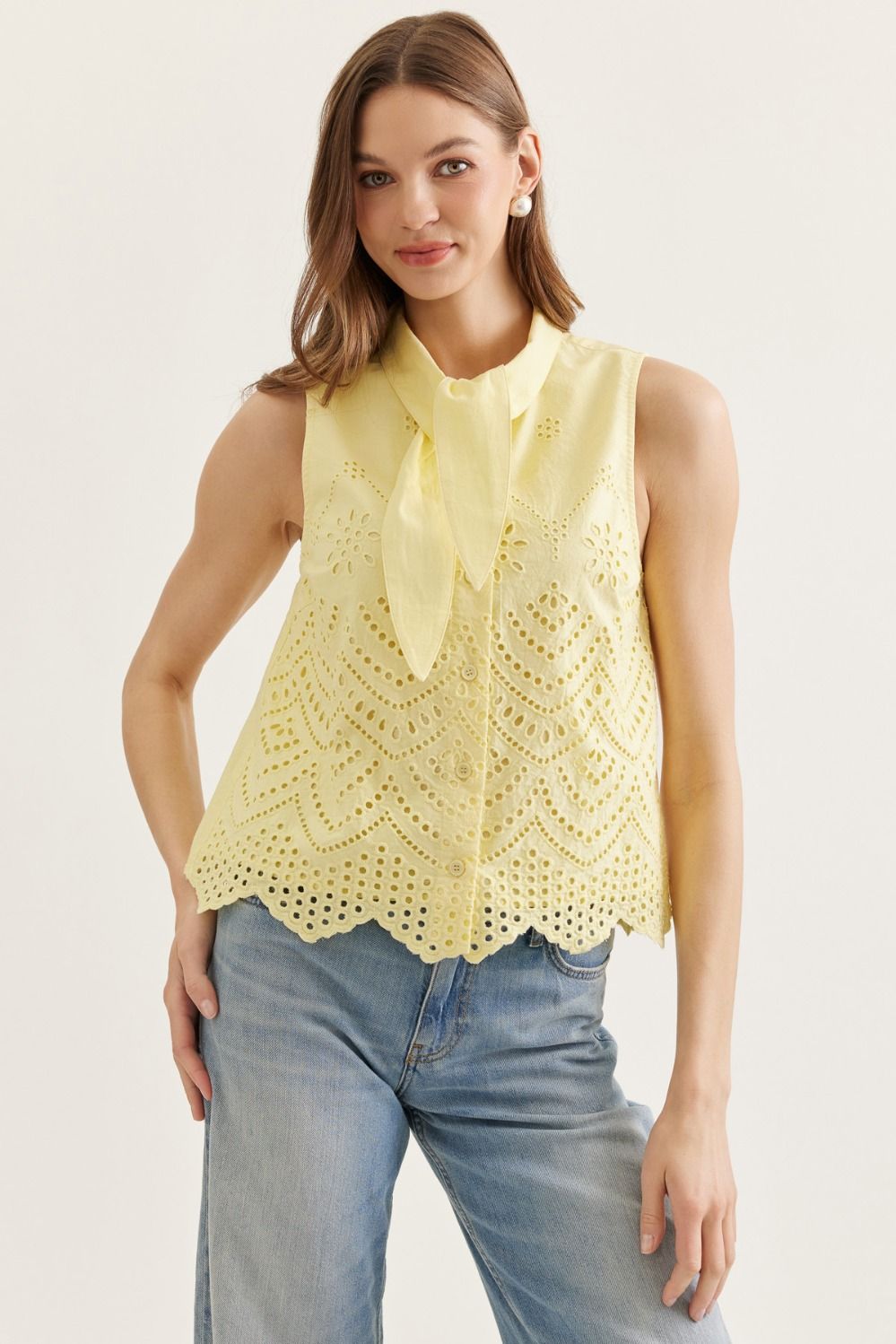 cotton sleeveless top with eyelet embroidery, tie-neck detail, and scalloped hem