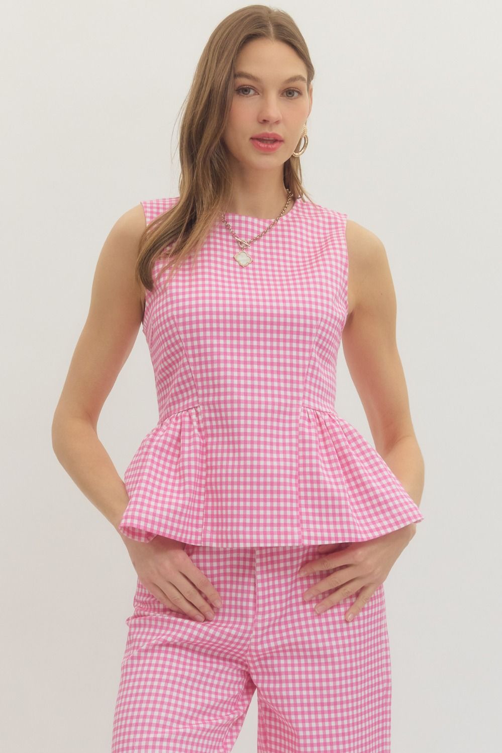 gingham sleeveless top with a structured waist seam and flattering peplum silhouette