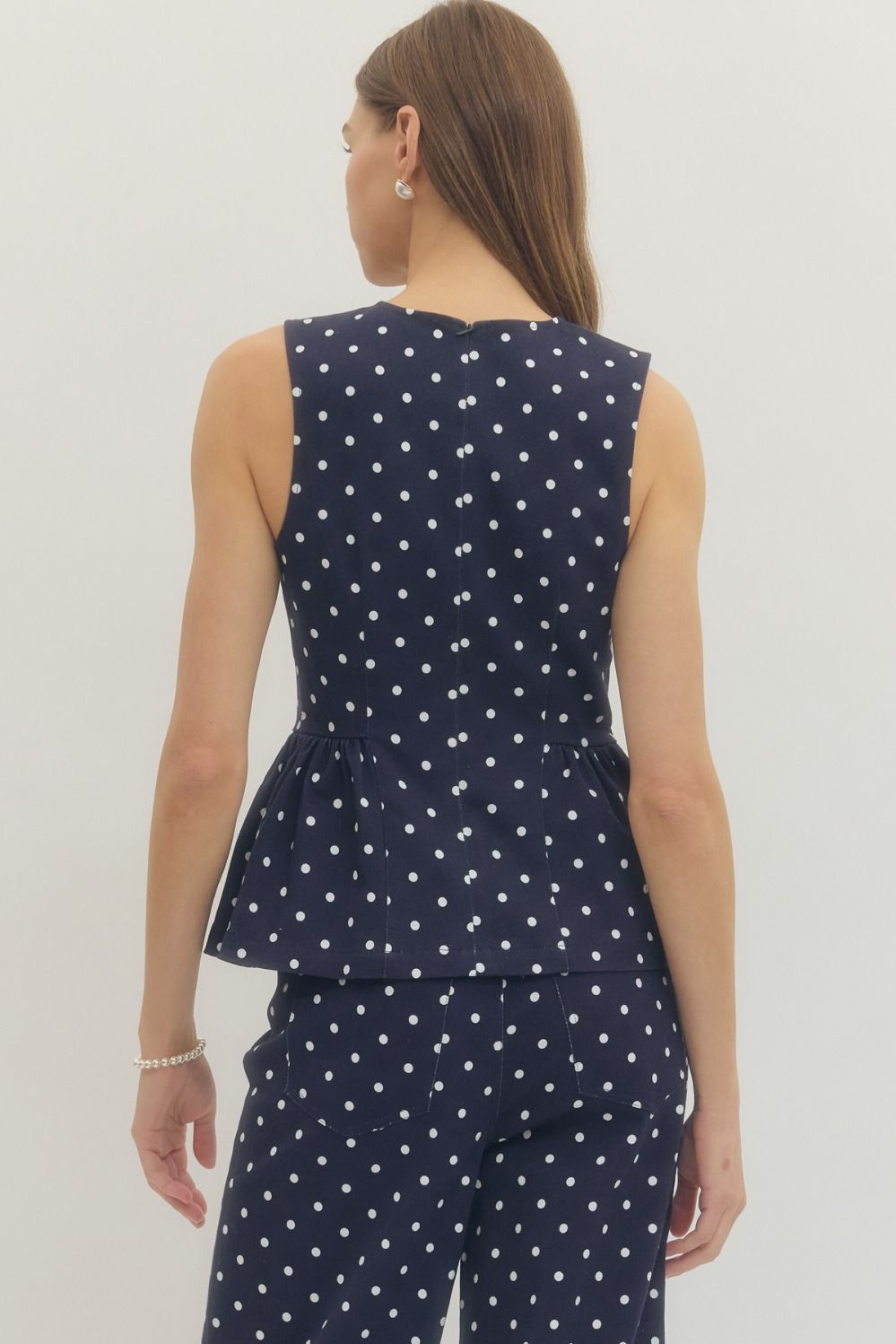 sleeveless polka dot top with a flattering peplum hem and tailored fit