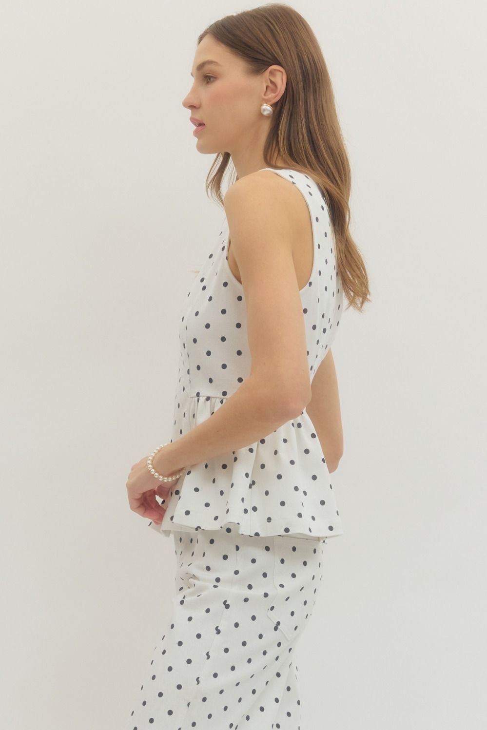 sleeveless polka dot top with a flattering peplum hem and tailored fit