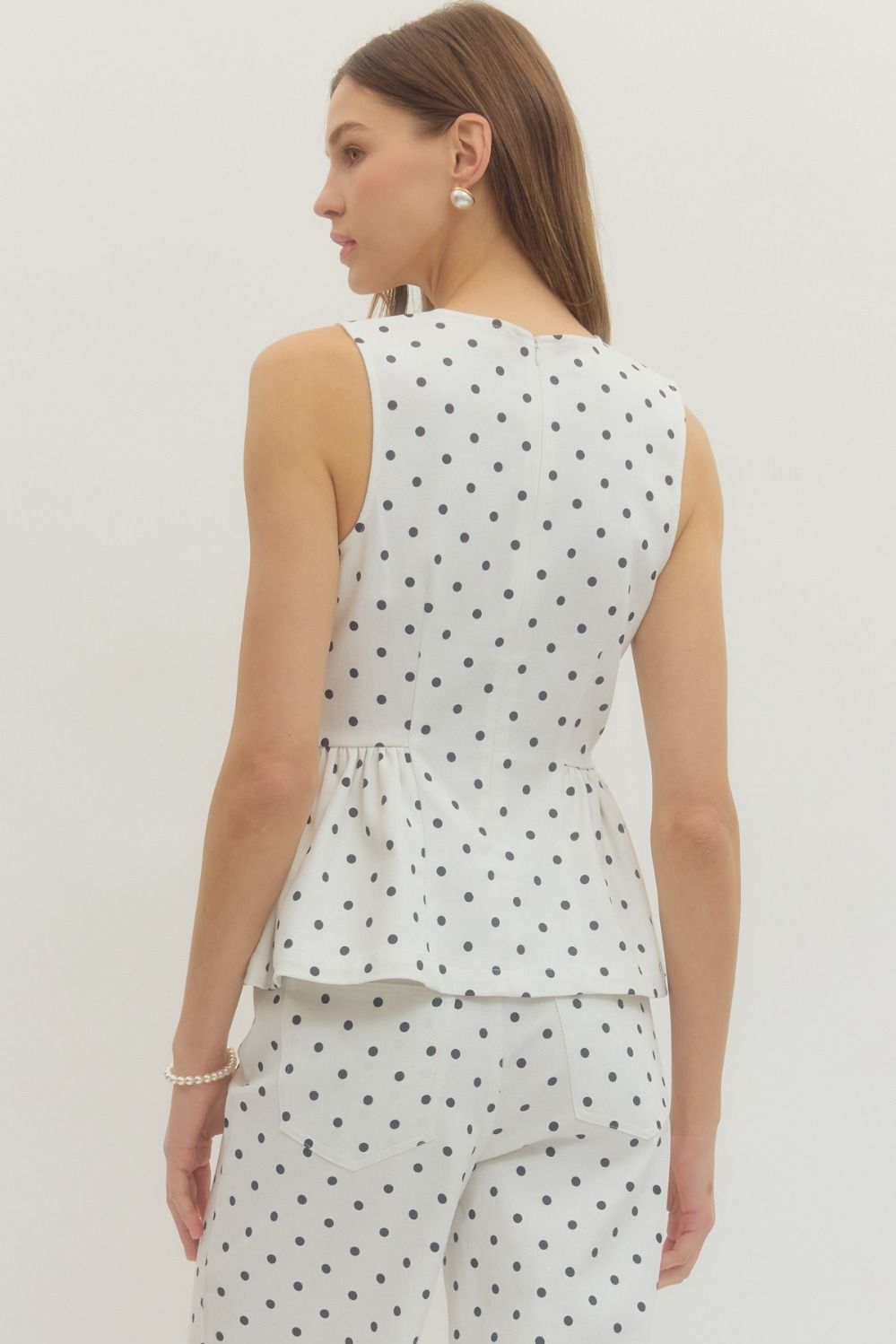 sleeveless polka dot top with a flattering peplum hem and tailored fit