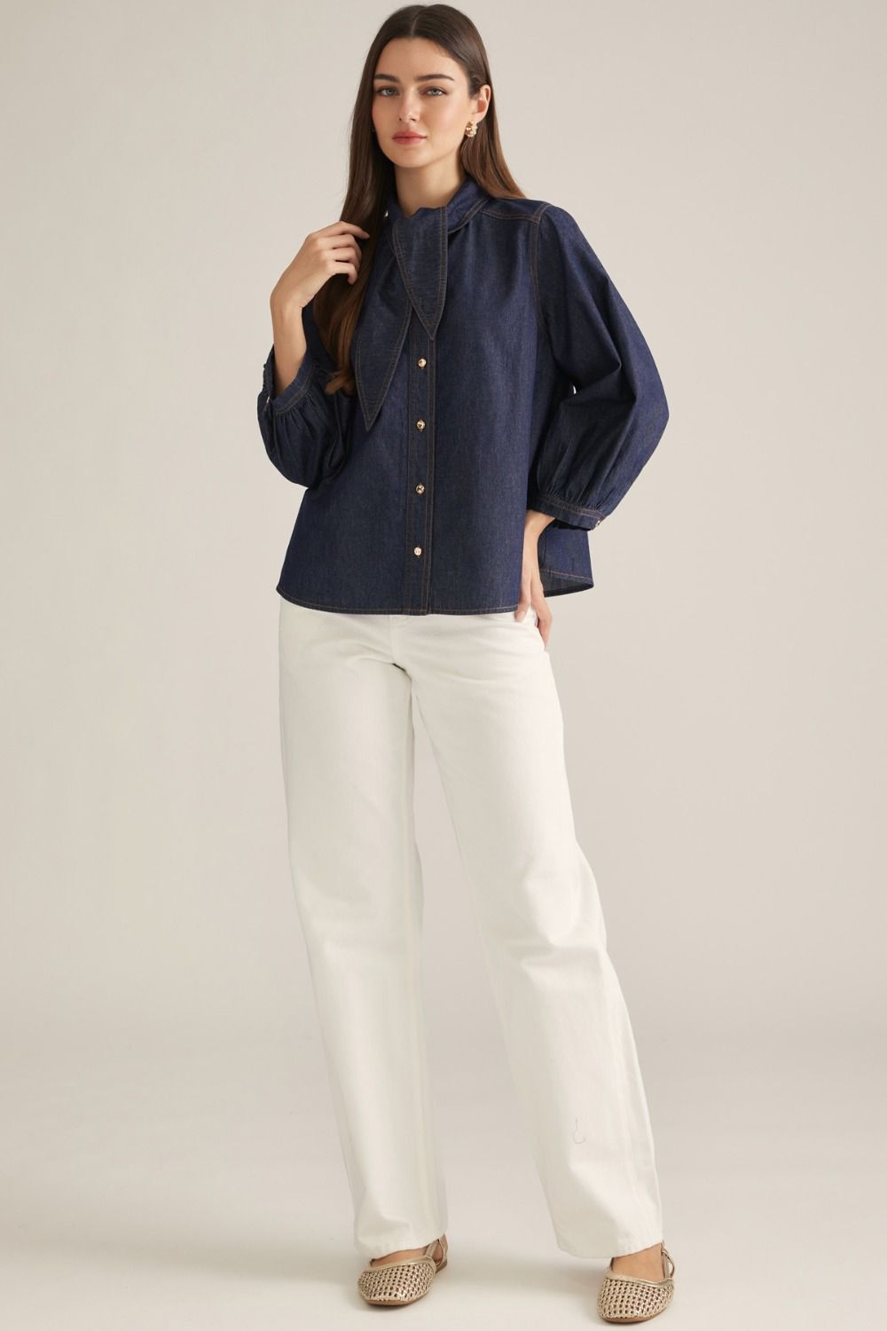 Women's denim-inspired woven top with high neckline, necktie detail, three-quarter puff sleeves, button front, and back pleats