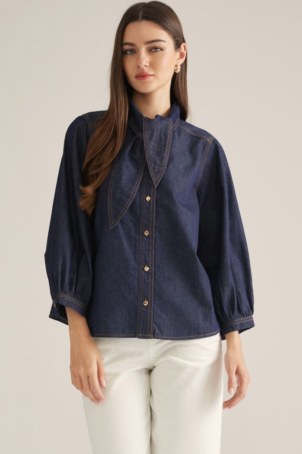 Women's denim-inspired woven top with high neckline, necktie detail, three-quarter puff sleeves, button front, and back pleats