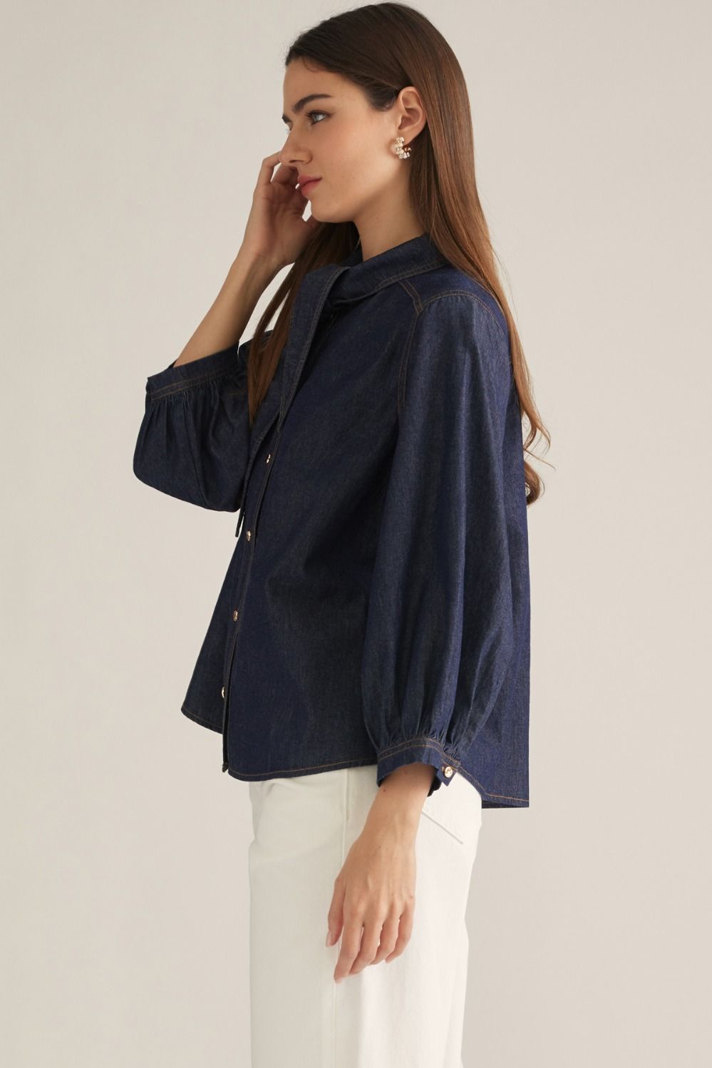 Women's denim-inspired woven top with high neckline, necktie detail, three-quarter puff sleeves, button front, and back pleats